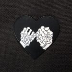 Pin corazon manos calaveras
