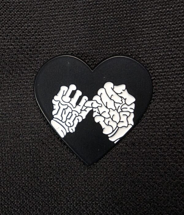 Pin corazon manos calaveras