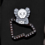 Pin para gorra New Era con diseño exclusivo de Kaws. Perfecto para personalizar tu gorra y otros accesorios con estilo artístico.