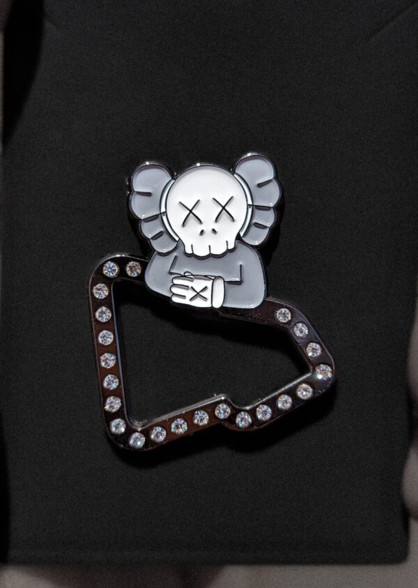 Pin para gorra New Era con diseño exclusivo de Kaws. Perfecto para personalizar tu gorra y otros accesorios con estilo artístico.