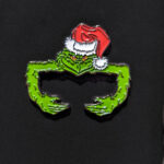 Pin para gorra New Era con diseño del Grinch. Añade un toque navideño y divertido a tu gorra.